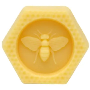 Hexagonal yellow beeswax block with a bee design in the center on a white background
