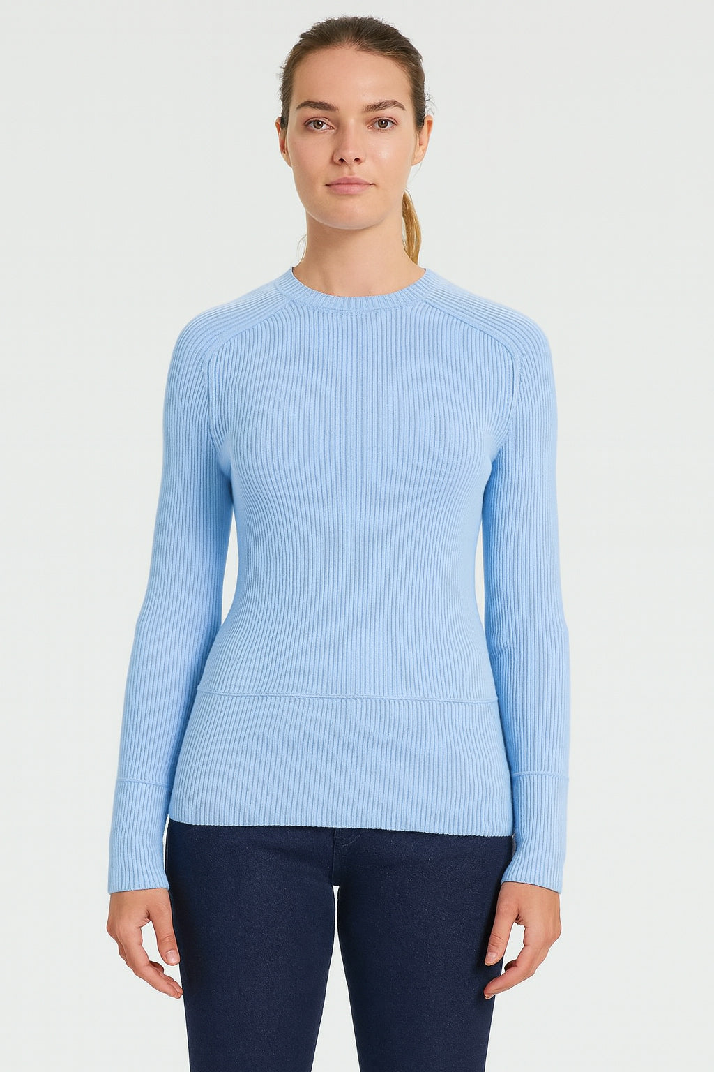 Woman wearing a light blue sweater against a white background