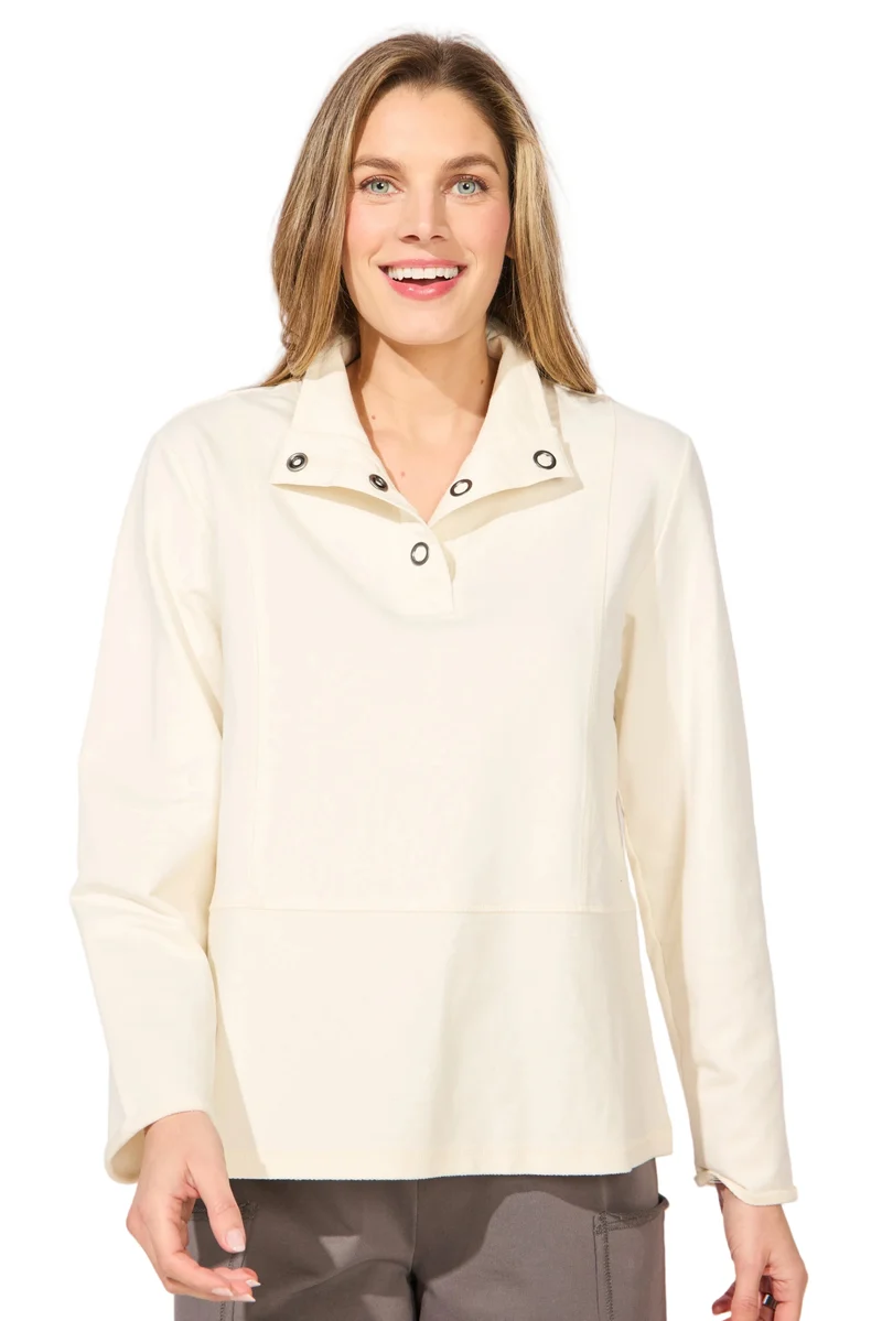 A woman wearing a cream-colored long-sleeve collared top with snap-button details at the collar ESCAPE BY HABITAT OCEAN FRONT TERRY QUARTER SNAP - 30134 Color Pearl