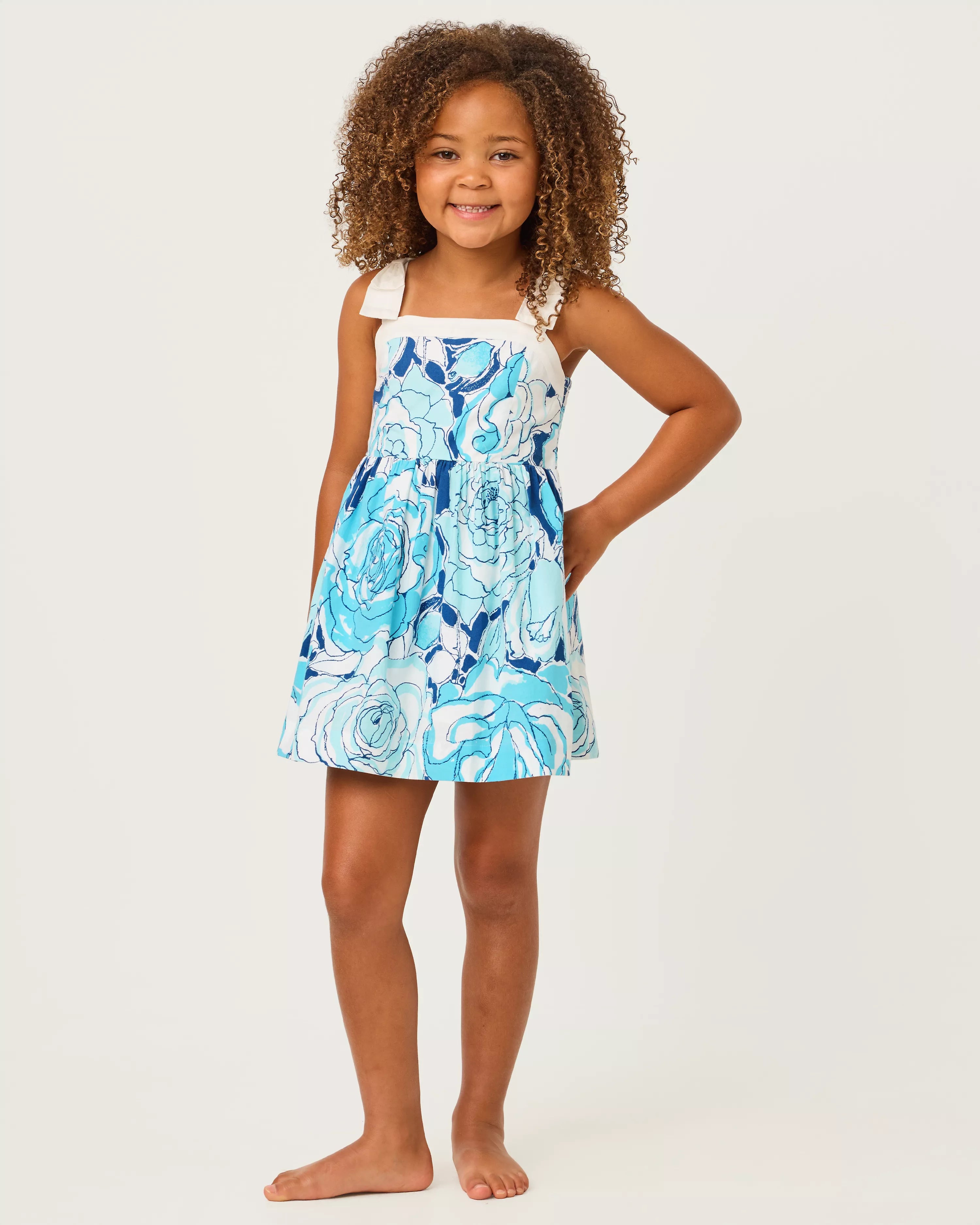 Young girl wearing a blue floral dress on a white background