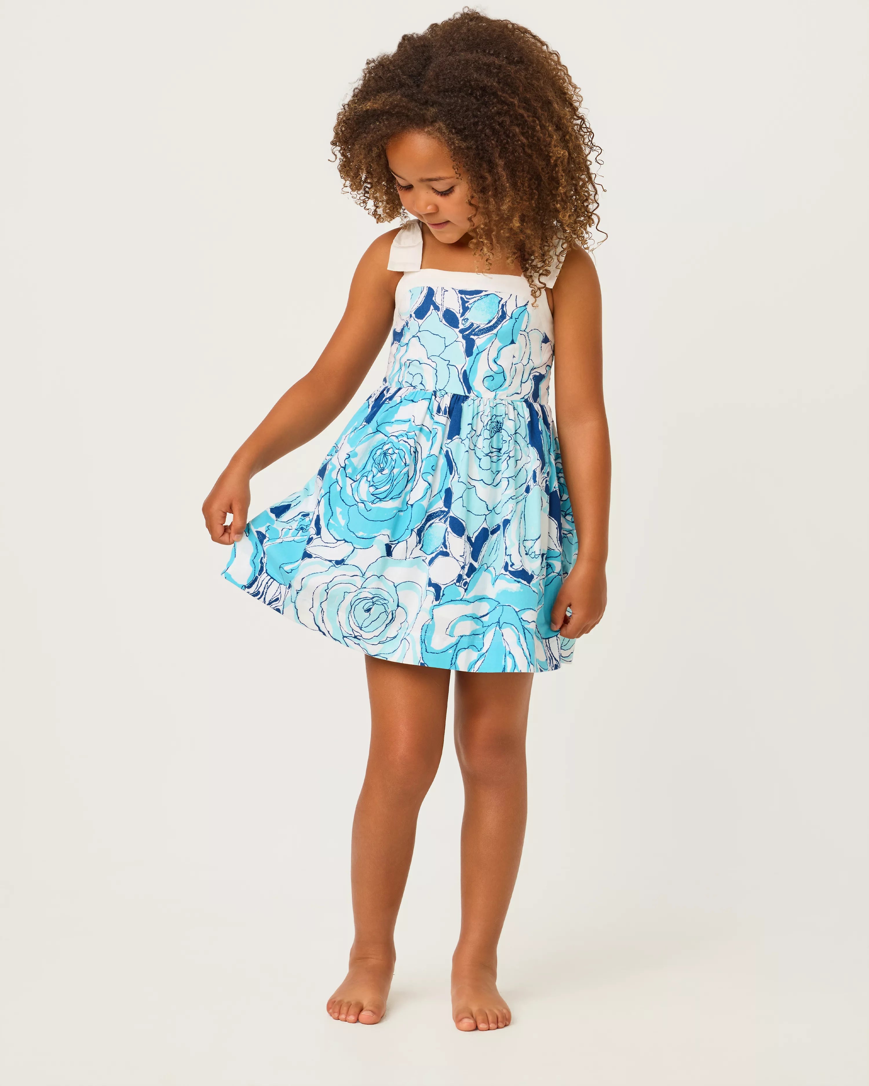 Young girl wearing a blue floral dress on a white background