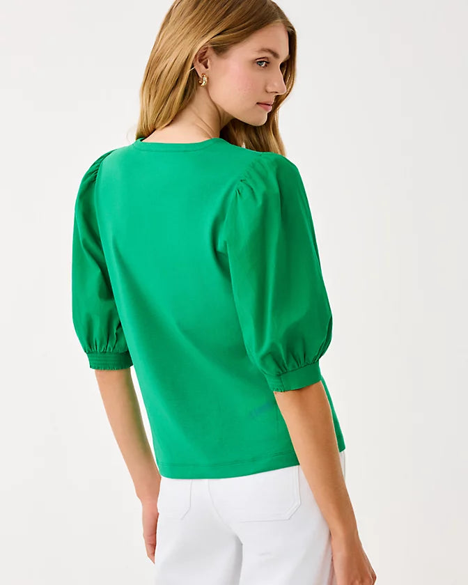 Woman wearing a green blouse with puffed sleeves on a white background