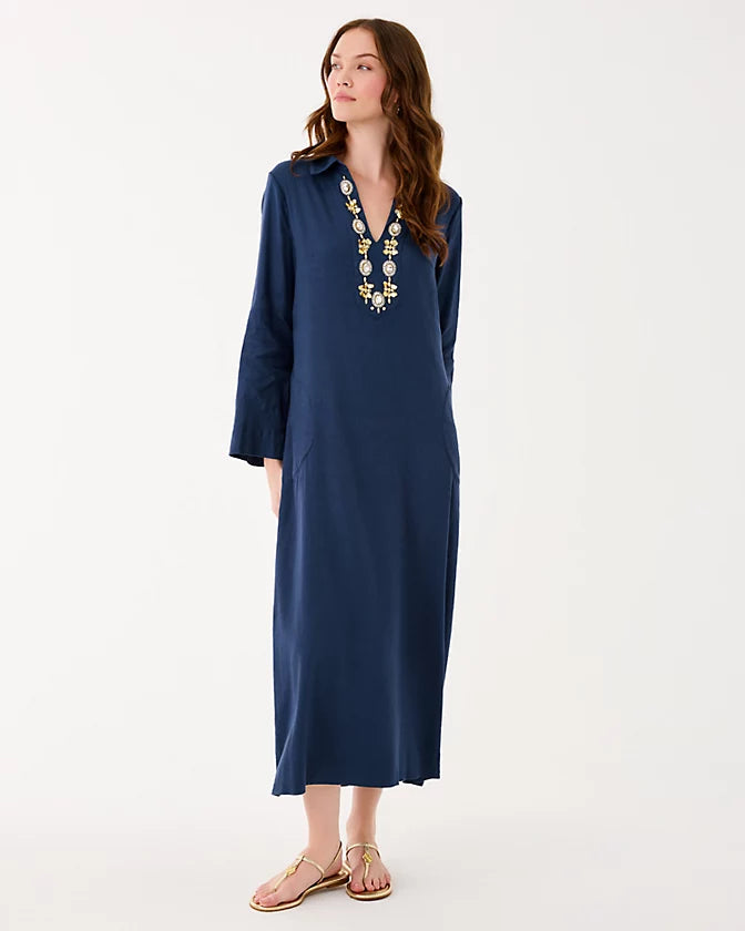 Woman wearing a navy blue dress with a decorative neckline on a white background