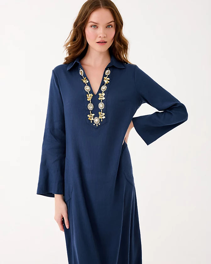 Woman wearing a blue dress with decorative neckline on a white background