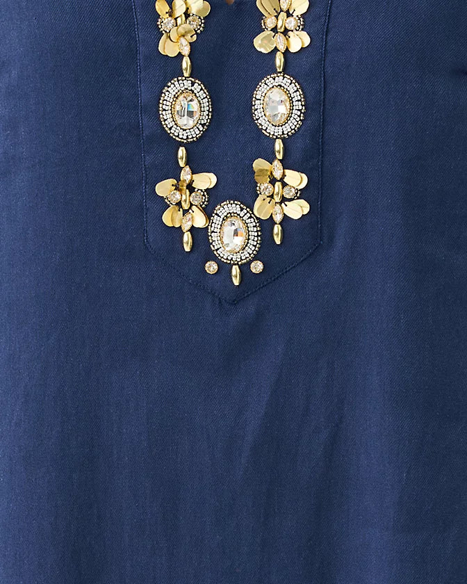 Gold necklace with floral and circular designs on a blue background