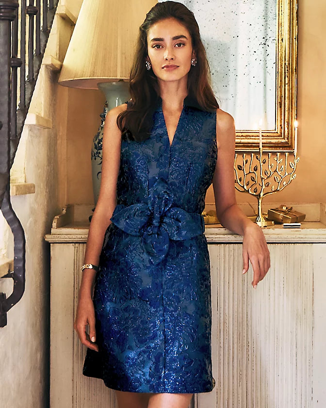 Woman wearing a blue lace dress in an elegant interior setting