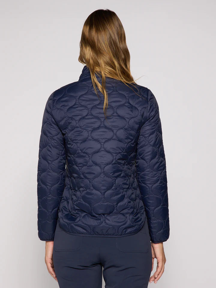 Person wearing a navy quilted jacket on a plain background