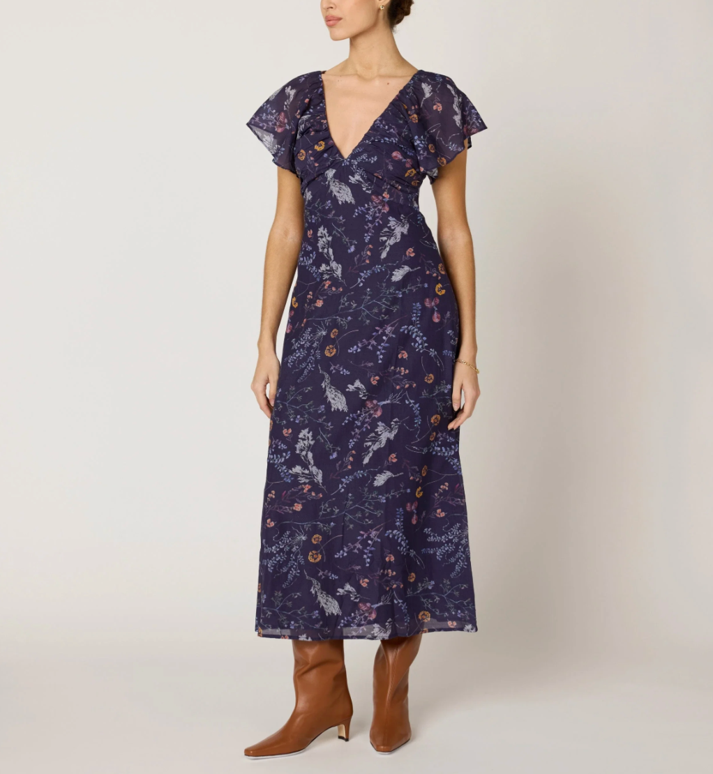 woman wearing dark blue midi dress, paired with brown boots