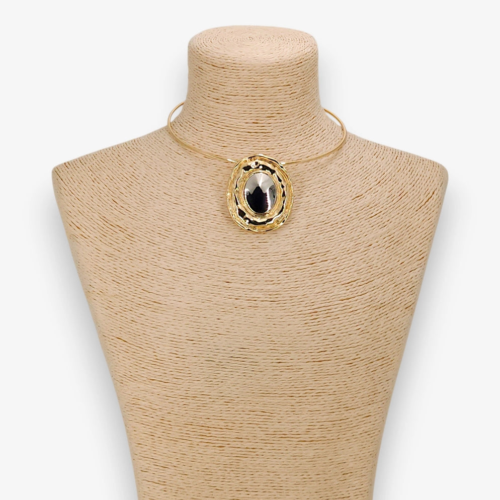 Gold necklace with a large pendant on a mannequin bust against a white background