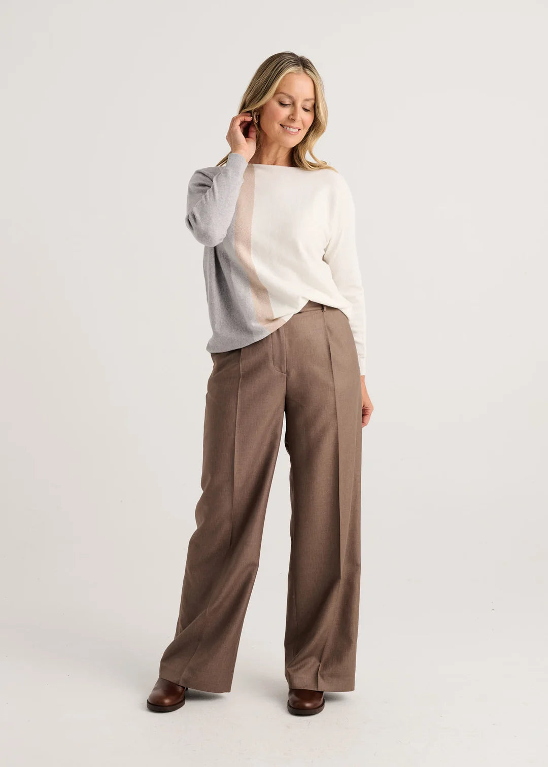 A woman modeling a color-block knit sweater with gray, cream, and beige vertical panels Zaket & Plover Vertical Lines Sweater in Snow