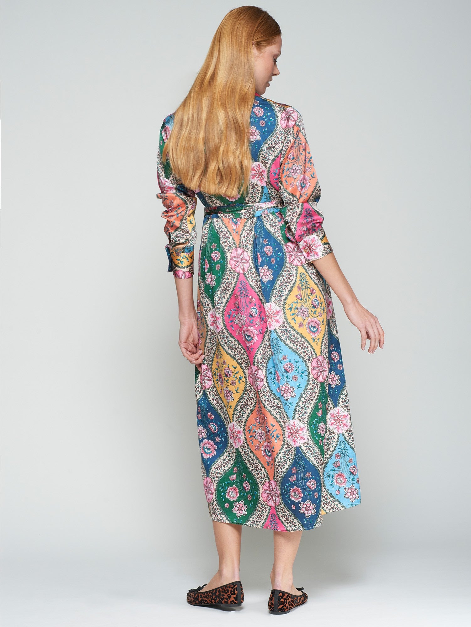 Woman wearing a colorful patterned dress on a white background