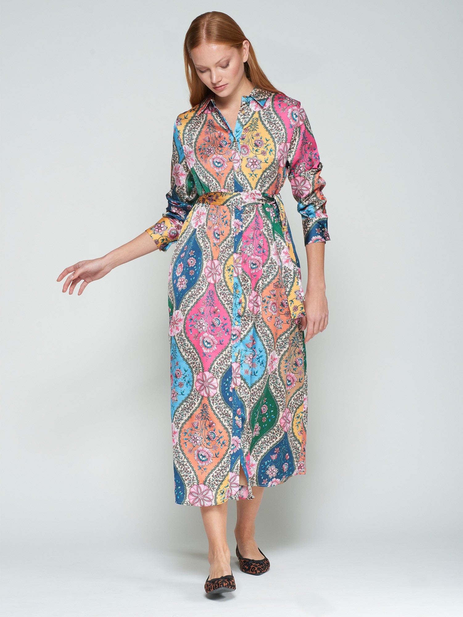 Woman wearing a colorful patterned dress on a white background