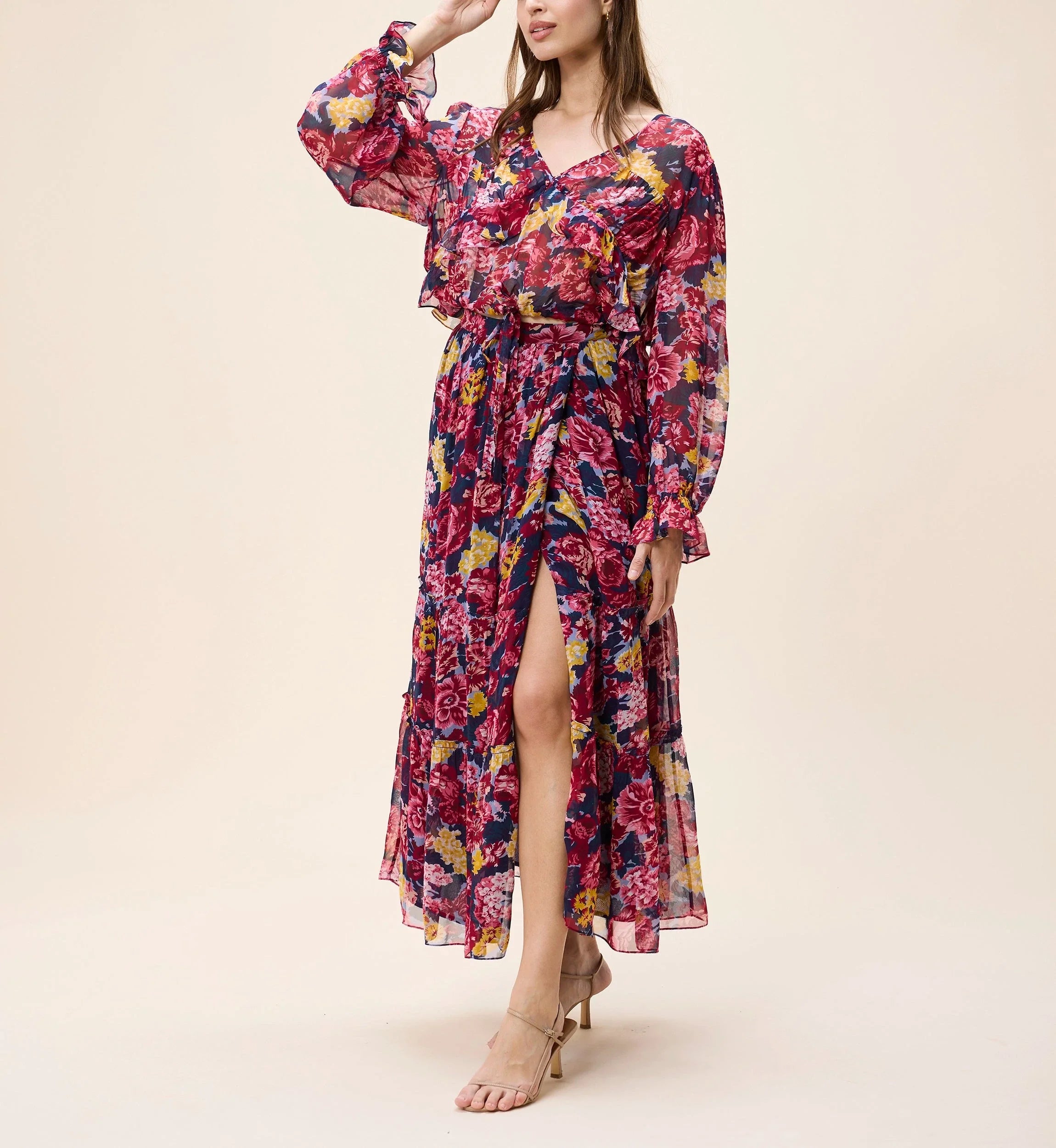 Woman wearing a colorful floral dress on a beige background