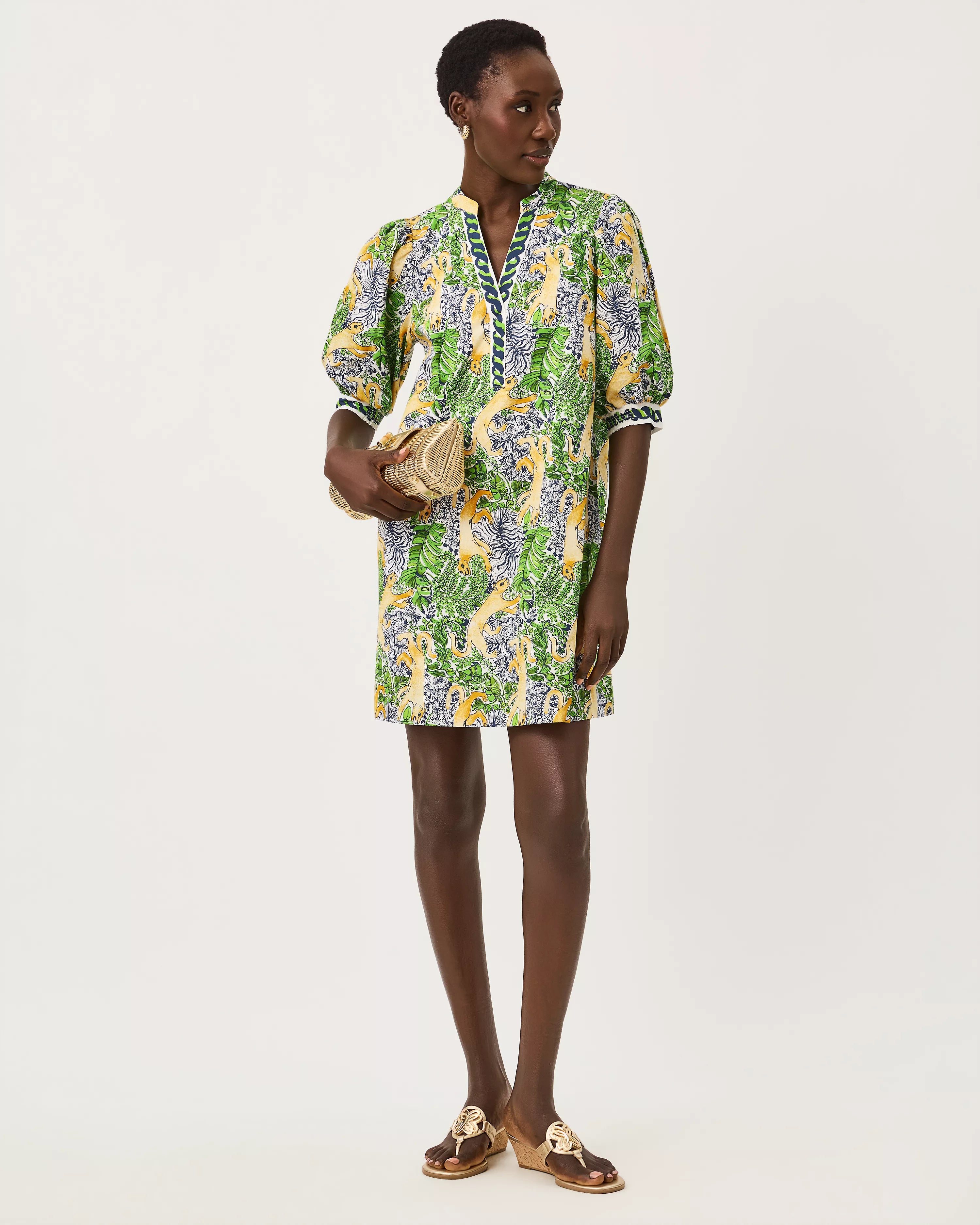 A woman modeling a short-sleeved mini dress with a vibrant green, yellow, and blue floral print lilly pulitzer mialeigh dress Color: Multi Lil Palm Prowl Engineered Woven Dress
