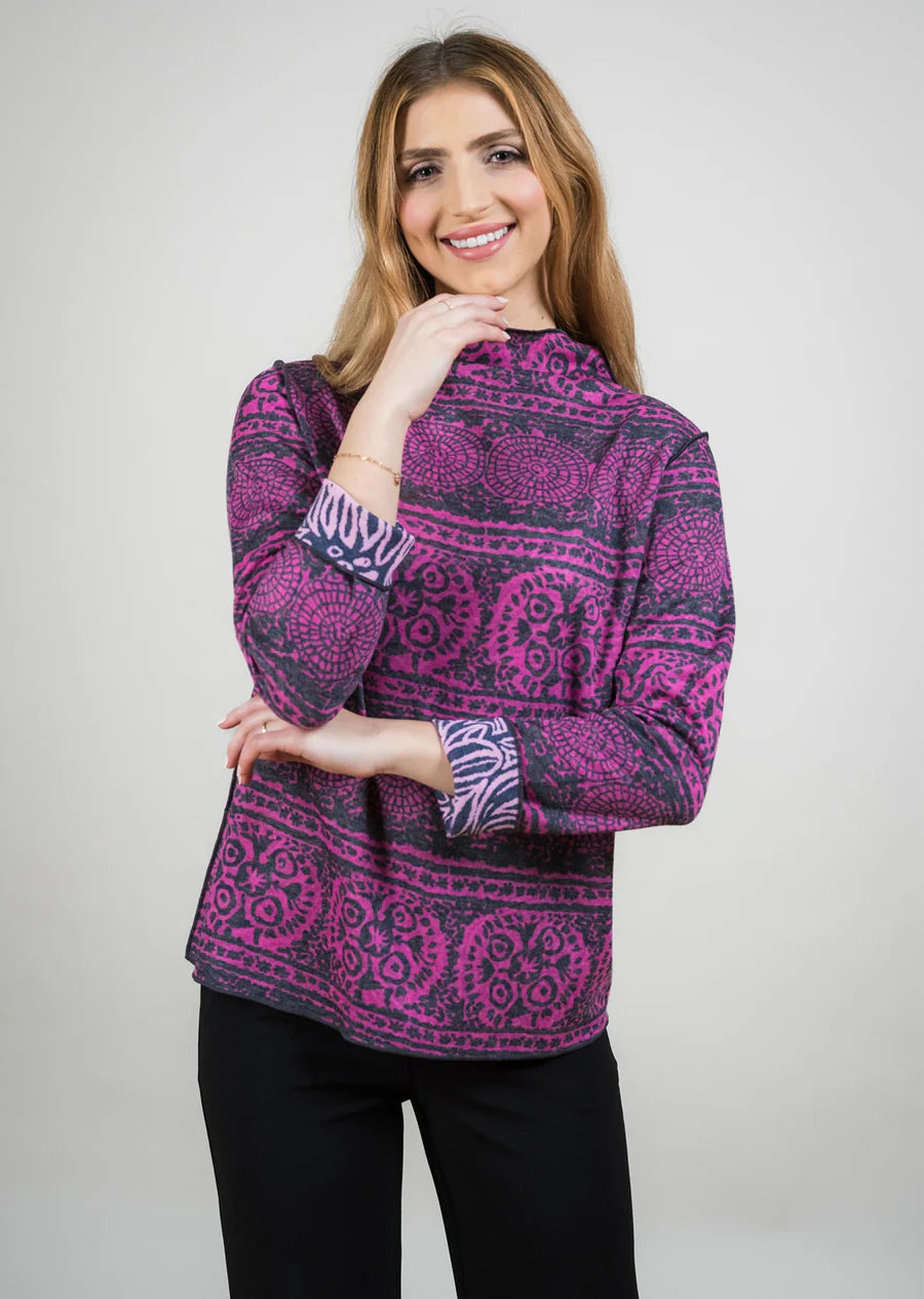 Woman wearing a purple patterned top against a white background