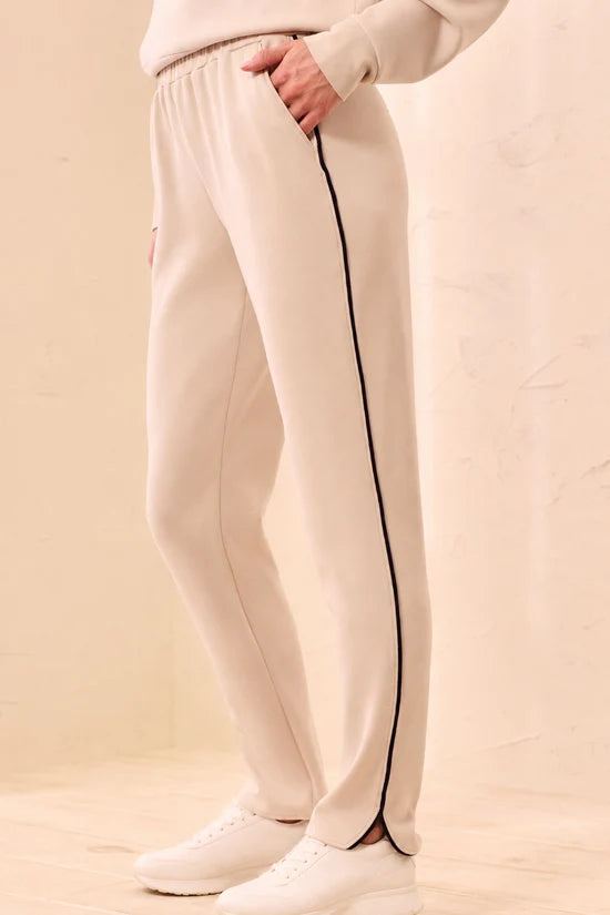 A woman modeling straight-leg pants, featuring thin black side stripes by tribal TECHNO LUX Jogger Pants With Contrast Piping And U-Hem