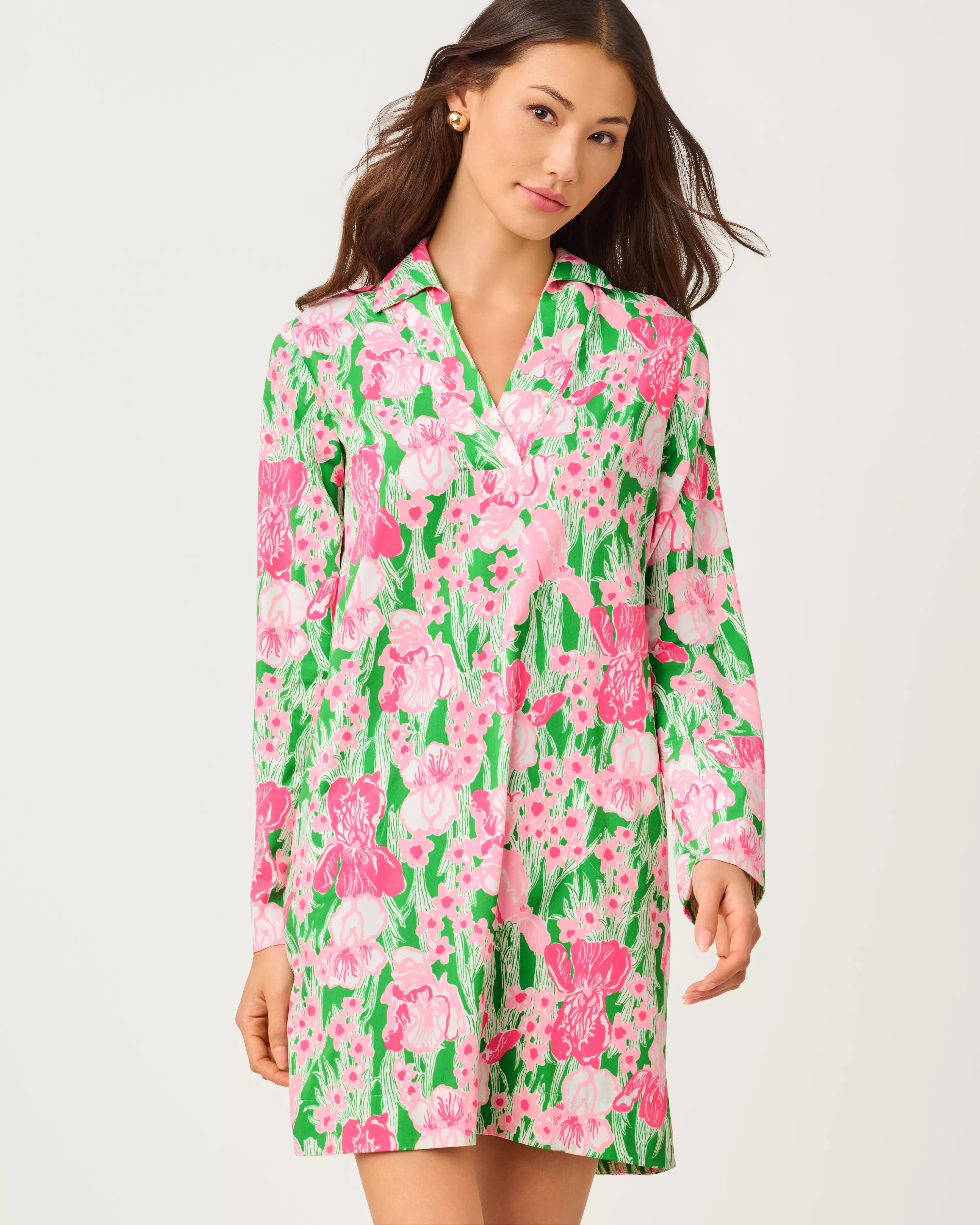 Woman wearing a floral dress with pink and green flowers on a white background