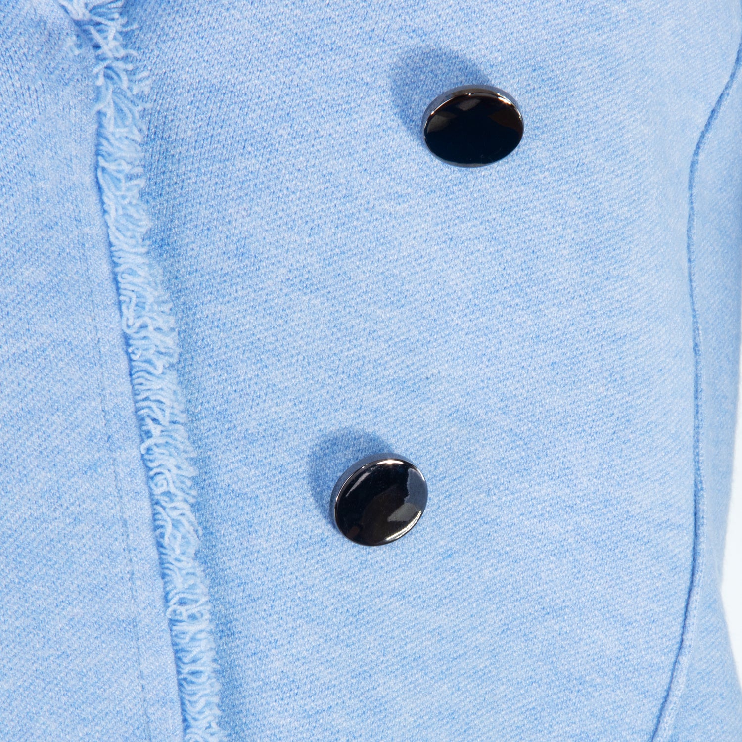 Close-up of a light blue denim jacket with two black buttons.