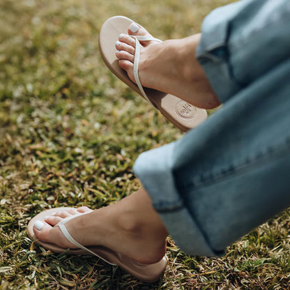 Person wearing white sandals on grass
