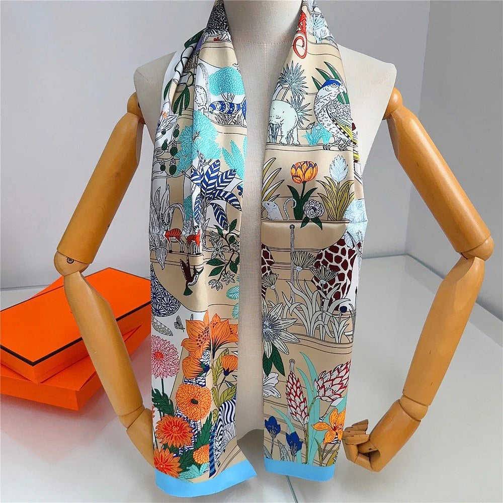 Colorful scarf with animal and floral patterns draped over a mannequin on a white background.