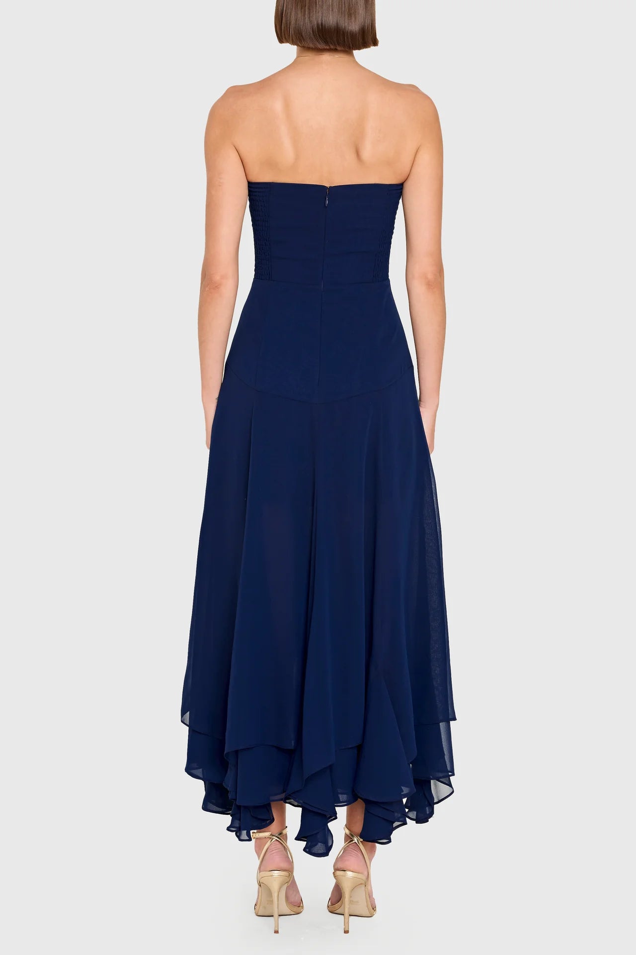 Navy strapless gown on a white background