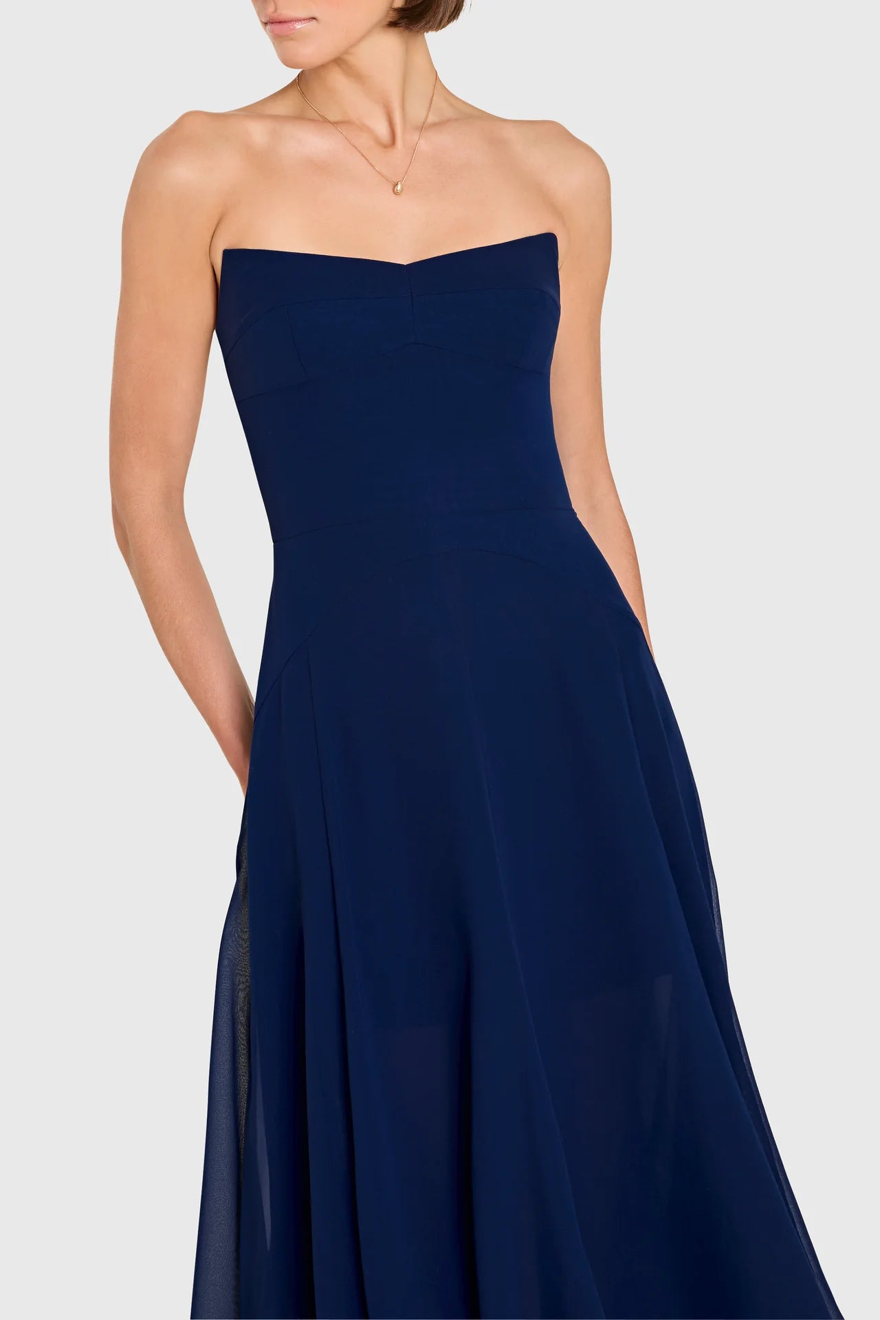 Navy strapless gown on a white background