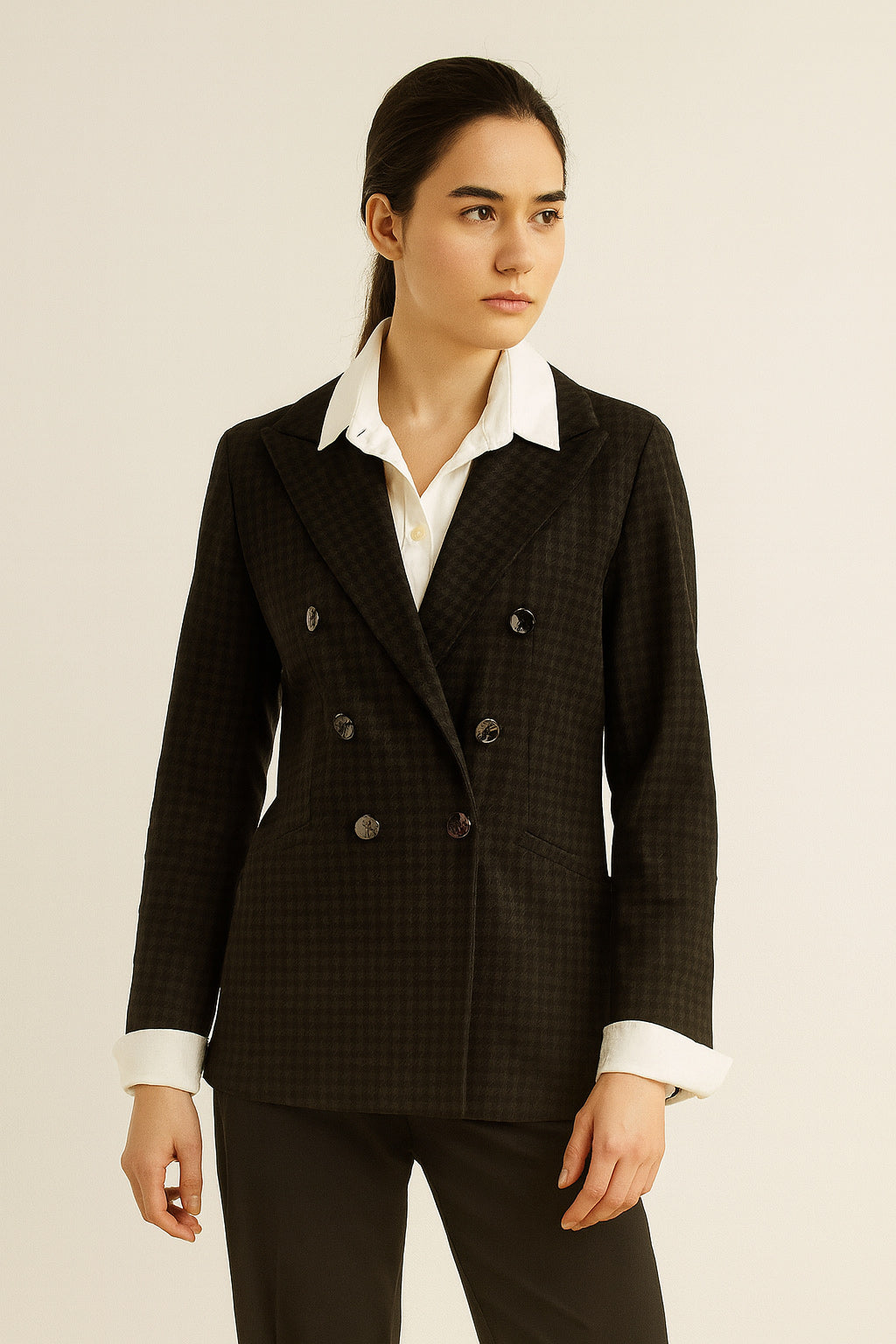 Woman wearing a black checkered blazer over a white shirt on a beige background