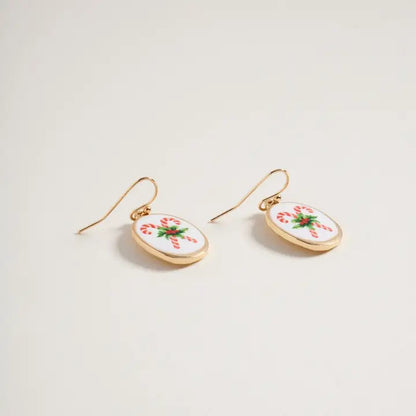 Pair of earrings with candy cane design on a light background