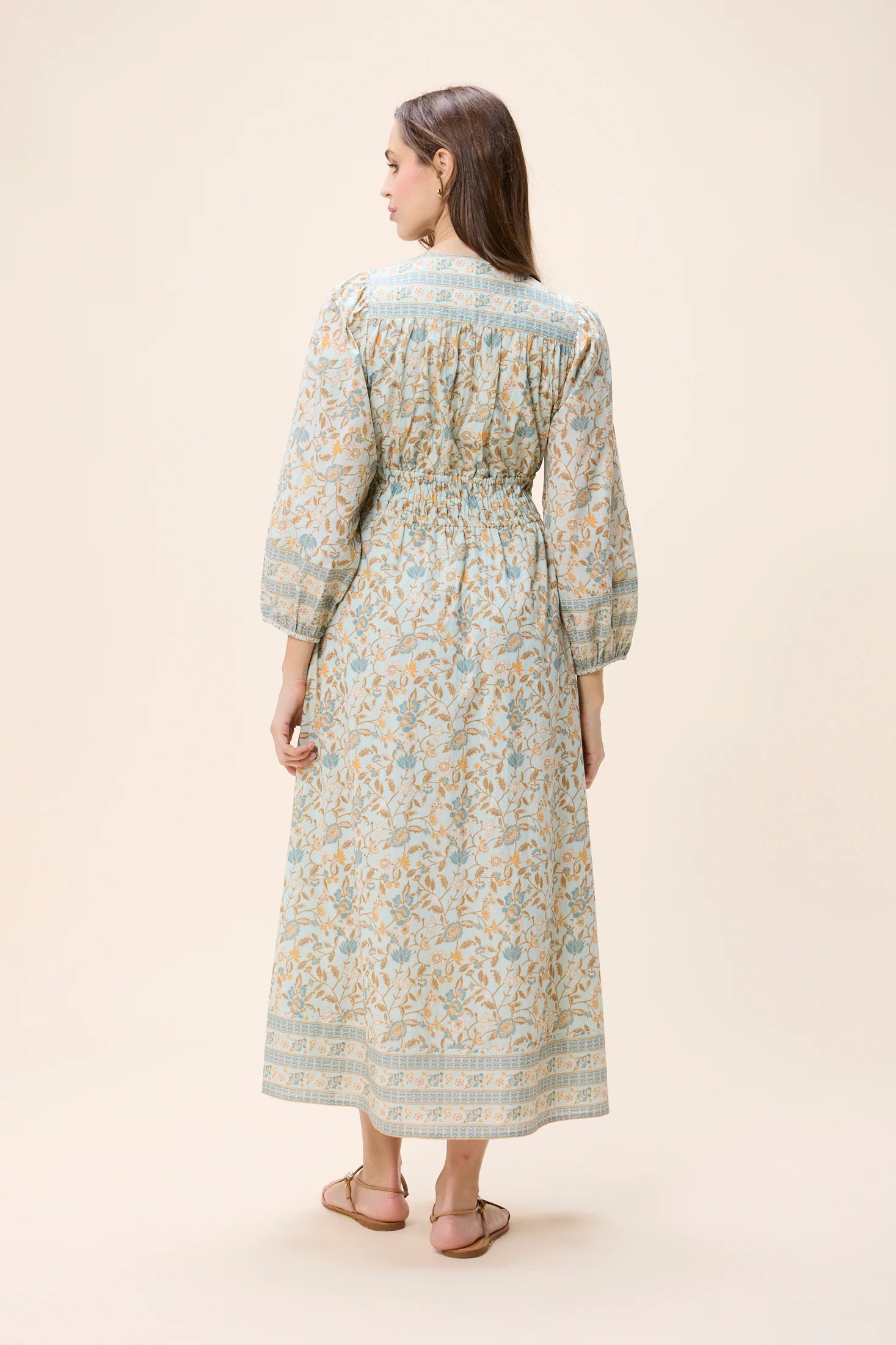 Woman wearing a floral dress on a beige background