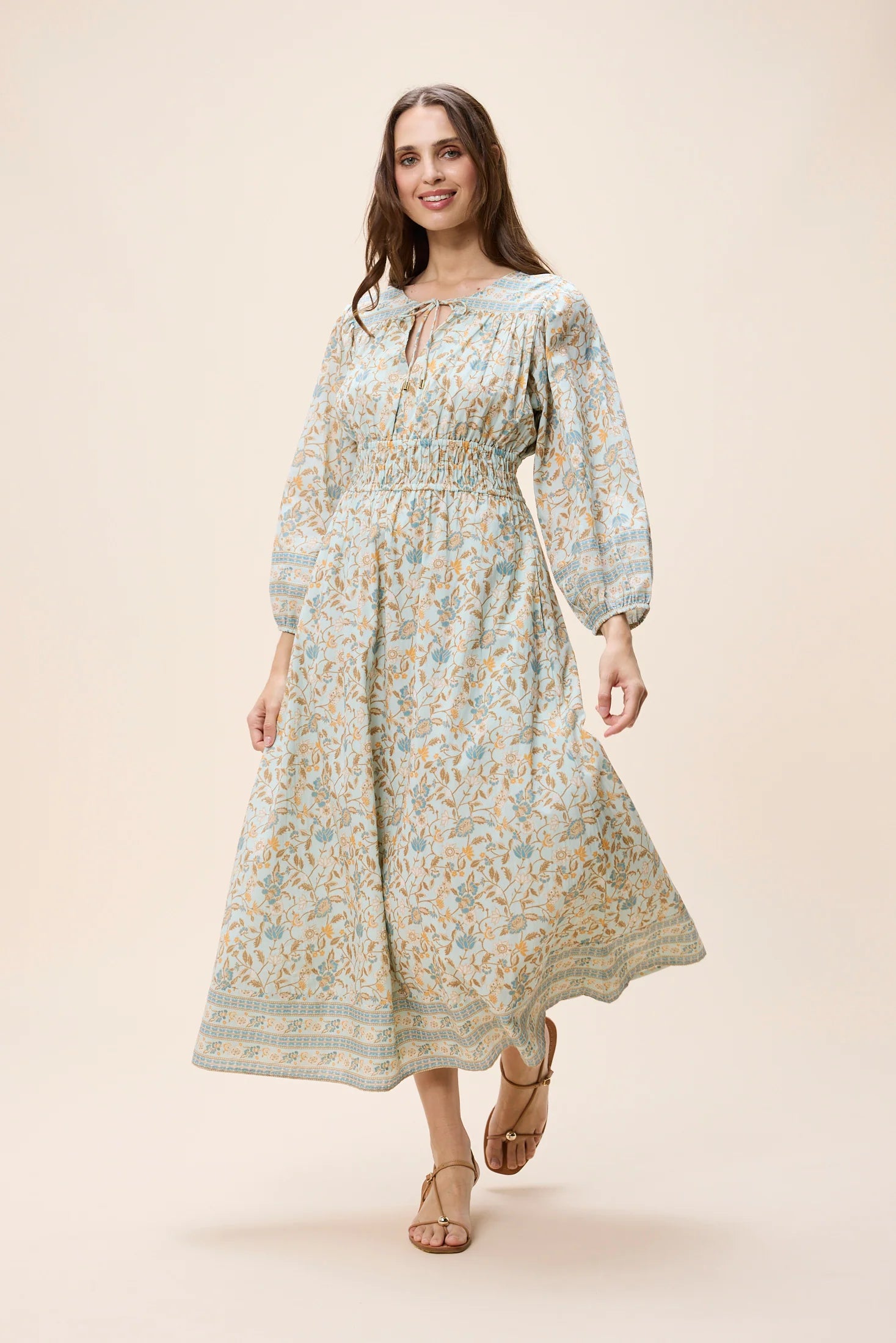 Woman wearing a floral dress on a beige background