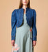 Woman Cleobella | Damien Denim Jacket blue denim jacket over a light green dress on a beige background