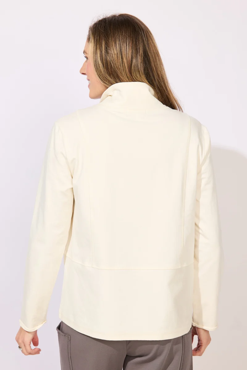 A woman wearing a cream-colored long-sleeve collared top with snap-button details at the collar ESCAPE BY HABITAT  OCEAN FRONT TERRY QUARTER SNAP - 30134 Color Pearl