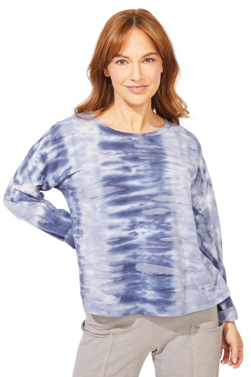 A woman wearing a blue and white tie-dye long-sleeve top    ESCAPE BY HABITAT  RIVER MODAL SPANDEX SUNSET PULLOVER - 45134 navy