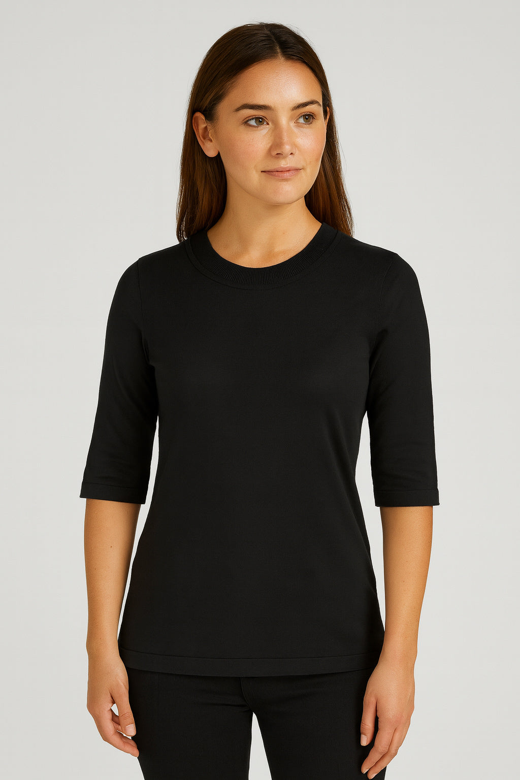 Woman wearing a black three-quarter sleeve shirt against a plain background