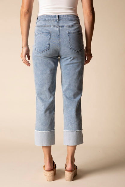 Light blue jeans worn by a person on a beige background