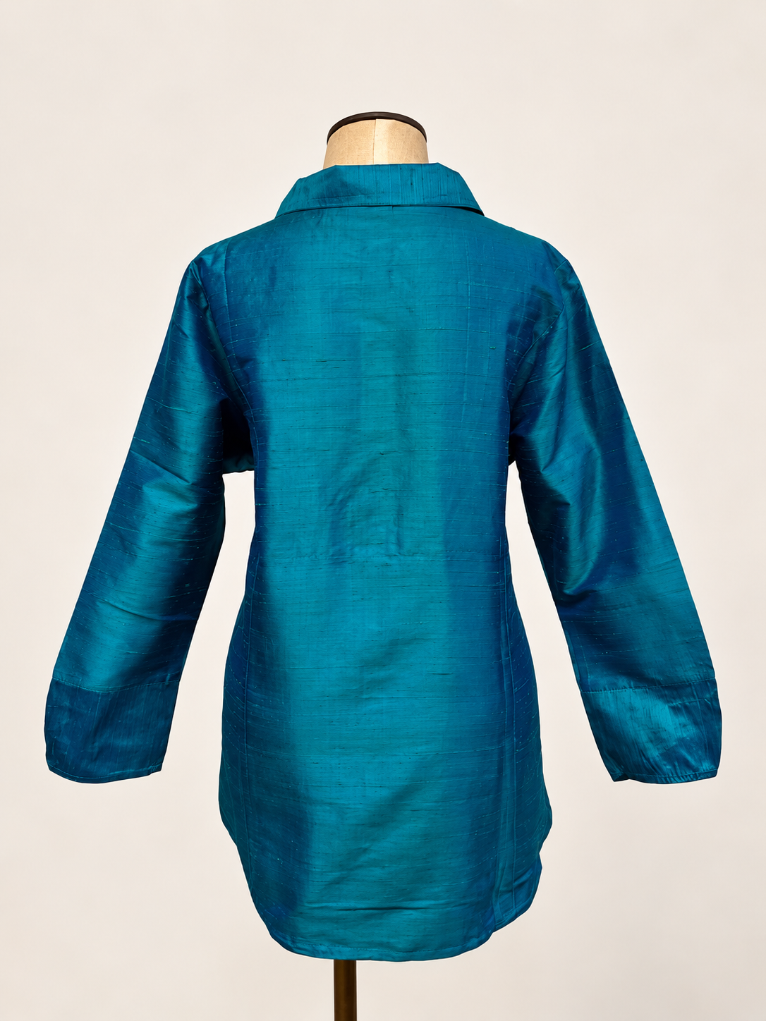 A teal blue long-sleeve silk shirt with a subtle woven texture, 