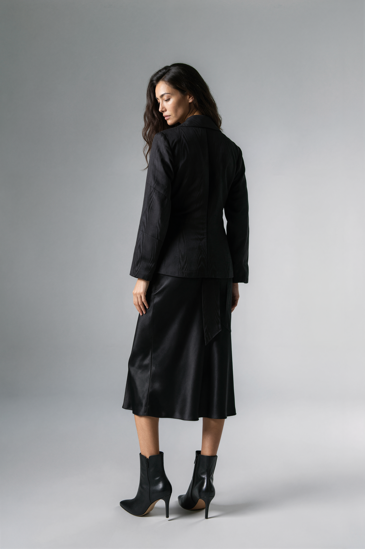 A woman modeling a black satin-like wrap coat J&