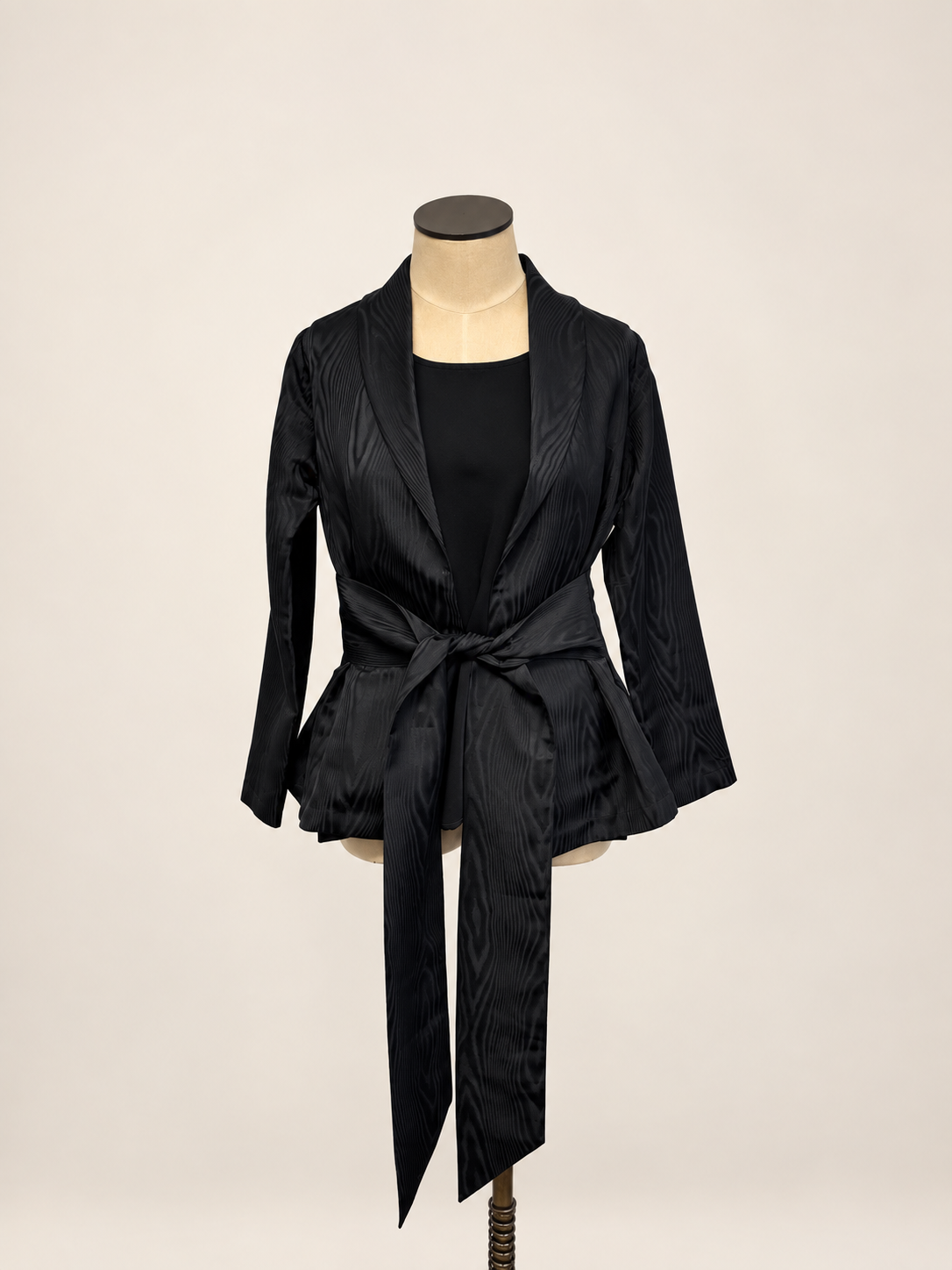 A woman modeling a black satin-like wrap coat J&