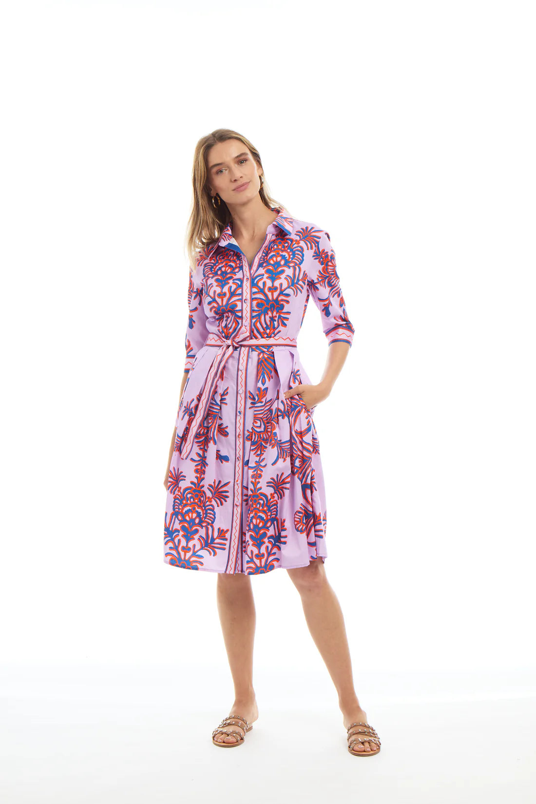 Woman wearing a colorful patterned dress on a white background