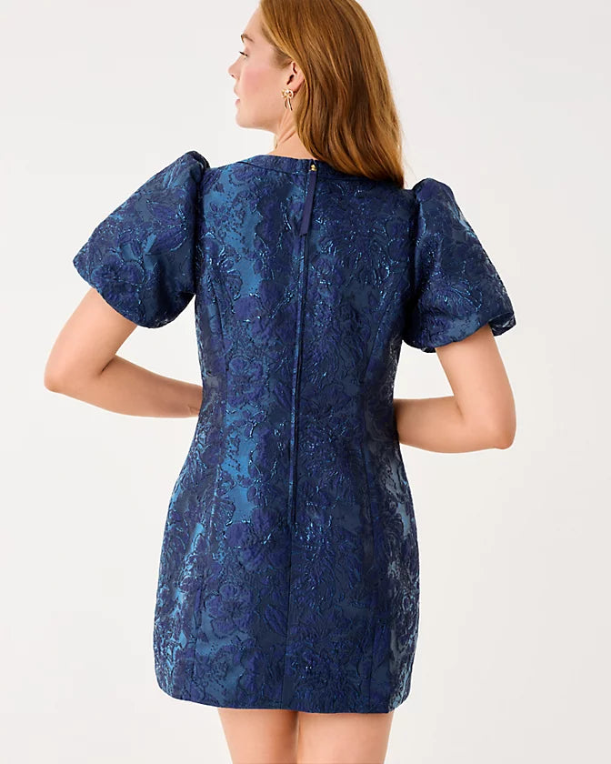 Woman wearing a blue patterned dress on a white background