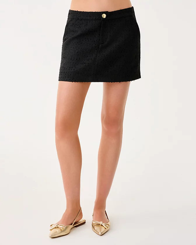 Black mini skirt worn by a person on a white background