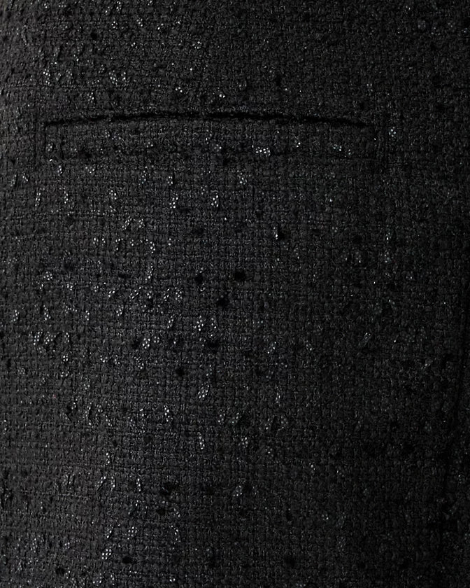 Close-up of a textured black fabric with a pocket detail