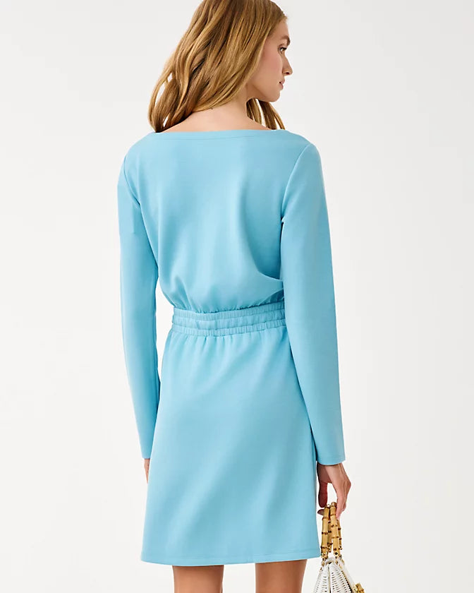 Woman wearing a light blue dress with long sleeves on a white background