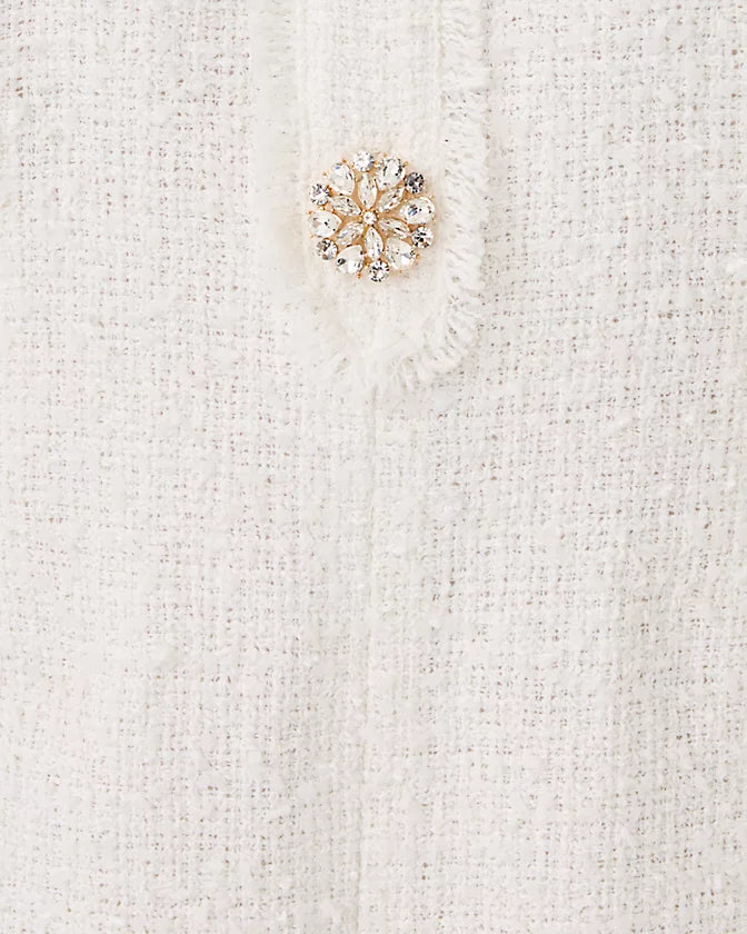 Gold snowflake brooch on a white textured fabric background