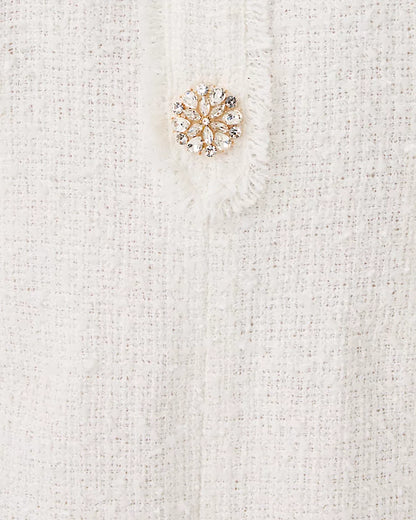 Gold snowflake brooch on a white textured fabric background
