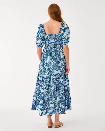 Woman wearing a blue floral dress on a white background
