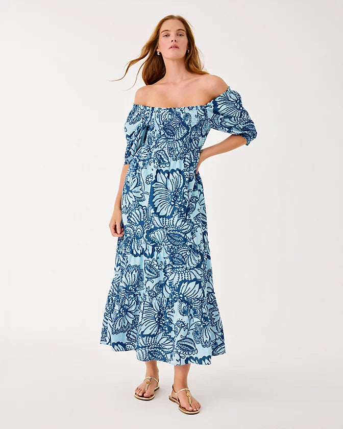 Woman wearing a blue floral off-shoulder dress on a white background