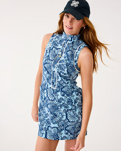 Woman wearing a blue floral dress and black cap on a white background