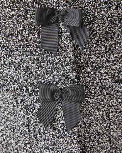 Close-up of a textured fabric with three dark gray bows.
