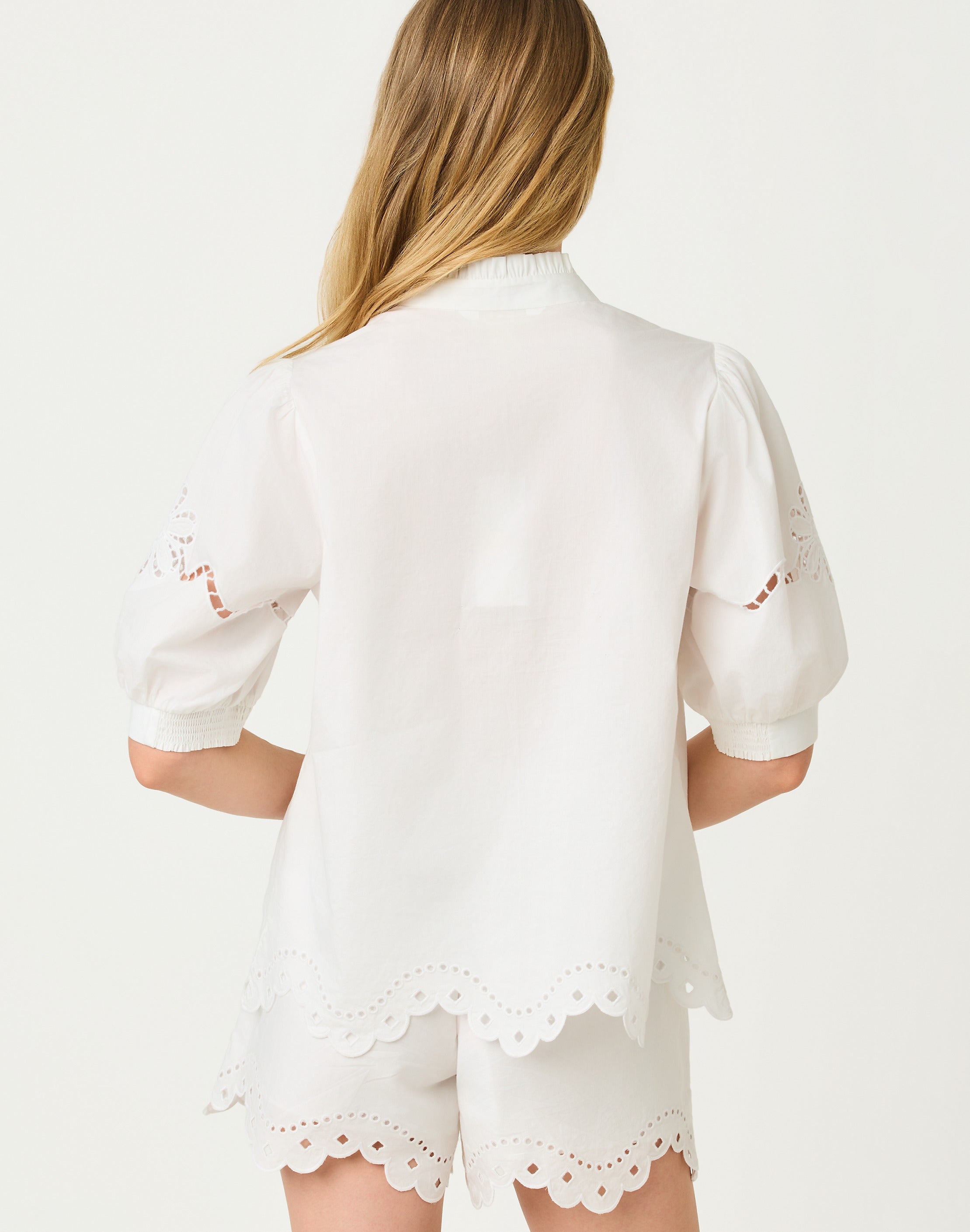 White outfit with lace details on a plain background